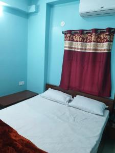 德奥加尔Hotel Ambika的红色窗帘的房间的一张床位