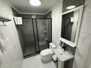塔拉兹Вояж的浴室配有卫生间、盥洗盆和淋浴。