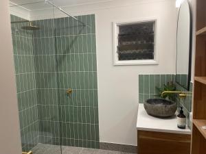 阿卡狄亚The Treehouse at Alma Bay的浴室设有绿色瓷砖和淋浴。