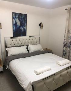 内罗毕Sandrock Residence的一间卧室配有一张大床,上面有两条白色毛巾