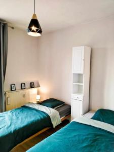 鲁贝Appartement Barbieux - Roubaix - 15min de Lille的一间卧室设有两张床和书架