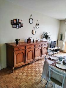 鲁贝Appartement Barbieux - Roubaix - 15min de Lille的一张桌子,房间里有一个大型的木橱柜