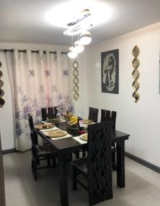 内罗毕Sandrock Residence的一间用餐室,配有黑色的桌子和椅子