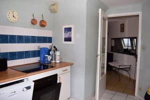 佩罗斯-吉雷克Appartement au dernier étage plage de Trestraou à PERROS-GUIREC - ref 858的厨房的墙壁上铺有蓝色和白色的瓷砖。