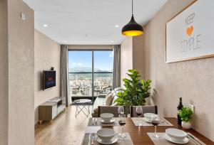 芽庄S Lux Apartment Virgo的一间配备有桌子的用餐室,享有城市美景。
