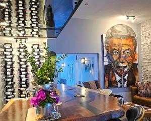 弗朗斯胡克Fleur du Soleil Luxury Guesthouse的一间房间,配有一张桌子和一幅画
