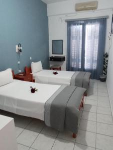 阿尔戈斯Hotel Theoxenia的酒店客房设有两张床和电视。