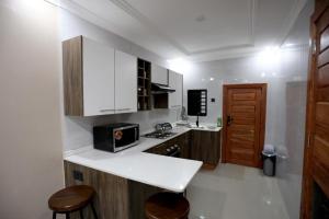 KitweCloud One Apartments的厨房配有白色橱柜和台面