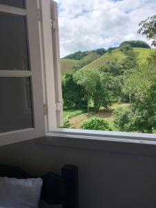 康赛瓦托利亚Pousada Talho da Serra的享有绿色田野景致的窗户