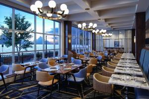 伊利Sheraton Erie Bayfront Hotel的餐厅设有桌椅和大窗户。