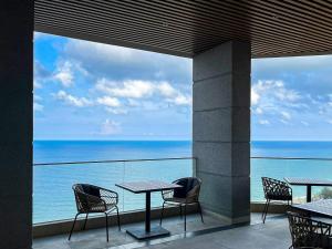 潘切APEC MANDALA CDT - Resort的一个带桌椅的海景阳台