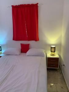拉斯特拉纳斯Caribbean Domicile的一间卧室配有一张带红色窗帘的床