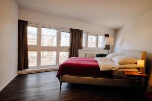 维也纳URBAN ISLAND I Riverside Apartments的一间卧室设有一张床和一个大窗户