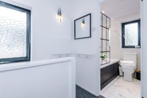 圣海伦斯New 2 Bed House - Perfect for Contractors & Families By AV Stays Short Lets St Helens的白色的浴室设有卫生间和窗户。