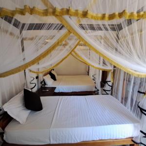 阿鲁甘湾Etnico Surf Resort的一间卧室配有两张带窗帘的床
