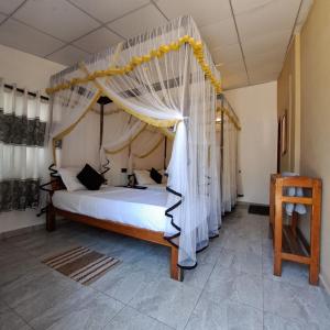 阿鲁甘湾Etnico Surf Resort的一间卧室配有一张带天蓬的床