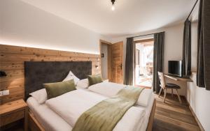 瓦尔奥纳的圣乔凡尼Enzianhof - Nature Apartments的一间卧室设有一张大床和一个窗户。