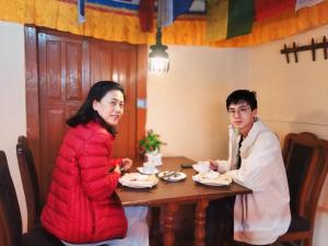 巴克塔普尔HOTEL RUPAKOT AND ROOFTOP RESTAURANT的坐在桌子上的男人和女人