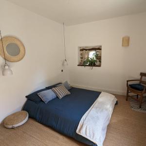 Saint-Mʼhervé拉贝勒韦尔特生态旅馆的一间卧室配有一张带蓝色棉被的床