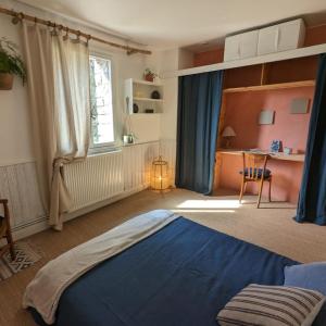 Saint-Mʼhervé拉贝勒韦尔特生态旅馆的一间卧室配有蓝色的床和一张书桌