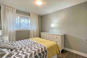 圣凯瑟琳市White House Suite - Sleeps 4的一间卧室配有带梳妆台和窗户的床。
