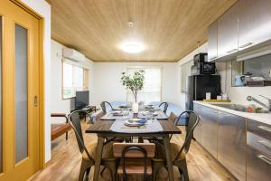 东京Premier suite Yoyogi front detached house的厨房以及带桌椅的用餐室。