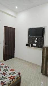 马图拉Hotel Shri kishori farm的客房设有一张床和一台平面电视。