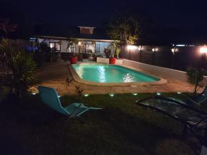 马罗尼河畔圣洛朗Hudace maison partagée的夜间在院子里的游泳池