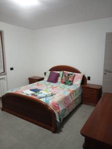 LuniColli di Luni的一间卧室配有一张带木制床头板的床