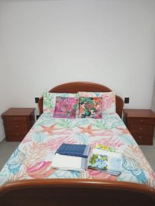 LuniColli di Luni的一张带彩色床罩的床,上面有书