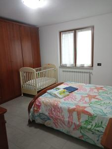 LuniColli di Luni的一间卧室配有一张床和两张婴儿床