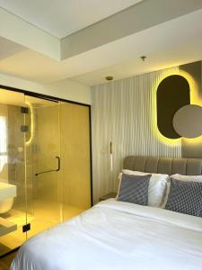 特拉维夫Allenbeach TLV- apart Hotel- Adults only的一间卧室设有一张床和一个玻璃淋浴间