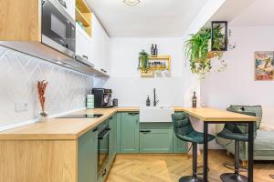 波亚纳布拉索夫Studio Guapo的厨房配有绿色橱柜和桌子