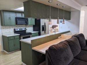 坦帕Executive Pool Home的一间厨房,内设绿色橱柜和一张沙发