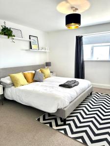 圣赫利尔泽西Eden Hotel - Beach Apartments & Suites的一间卧室配有一张带黄色枕头和地毯的床
