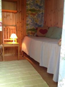 特鲁萨Lättillgängligt och trevligt hus的一间卧室配有一张床和一张带台灯的桌子