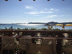 马里纳·迪·波迪斯科Luxury Apartment Sardegna的海滩上配有椅子和遮阳伞,享有大海美景