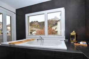 锡永Chambre d'hôte Valère的带2扇窗户的客房内的大浴缸