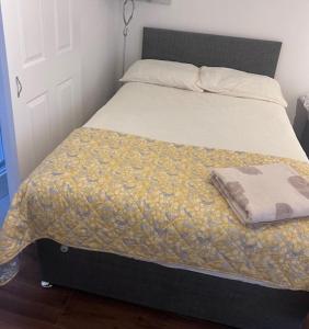 OltonSolihull Guest House 1的一张黑色床架和黄色毯子