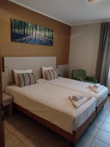 Bour关帝公寓式酒店的一间卧室配有一张大床和两条毛巾