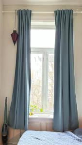 奥斯陆Oslo-Frogner的卧室内带蓝色窗帘的窗户