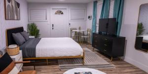 坦帕New Downtown Tampa Cottage for 4的一间卧室配有一张床、一台电视和一张桌子