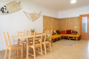 奇克拉纳－德拉弗龙特拉Namawa Surfhouse的一间带桌椅和沙发的用餐室