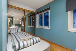 特罗姆瑟Villa Arctica的一间卧室设有蓝色的墙壁和一张带镜子的床