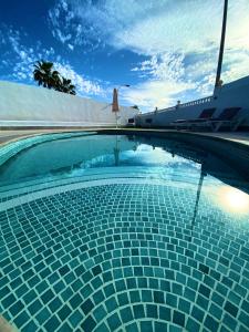 卡亚俄萨尔瓦赫Villa Sueño Azul的蓝色瓷砖游泳池,底下有船