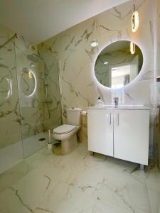 卡亚俄萨尔瓦赫Villa Sueño Azul的浴室配有盥洗池、卫生间和镜子。