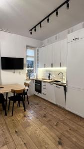 别尔斯克-比亚拉CityCenterApartments/M32/6的厨房配有白色橱柜和木桌