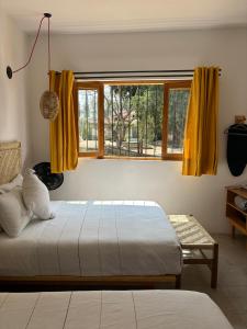 瓦哈卡市Santa Cecilia Hotel的一间卧室设有床和黄色窗帘的窗户