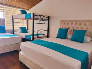 波哥大Hotel Batan 127的一间卧室配有两张双层床和蓝色枕头