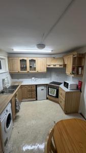 都柏林Double Room Clontarf House-3的一个带木制橱柜和桌子的小厨房